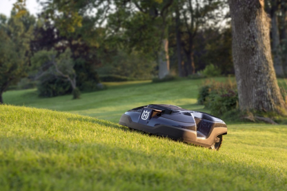 Melns Husqvarna zāles pļāvējs robots – Automower 310 modelis, darbības demonstrācija pļaujot zāli, augšup pa zemes paaugstinājumu