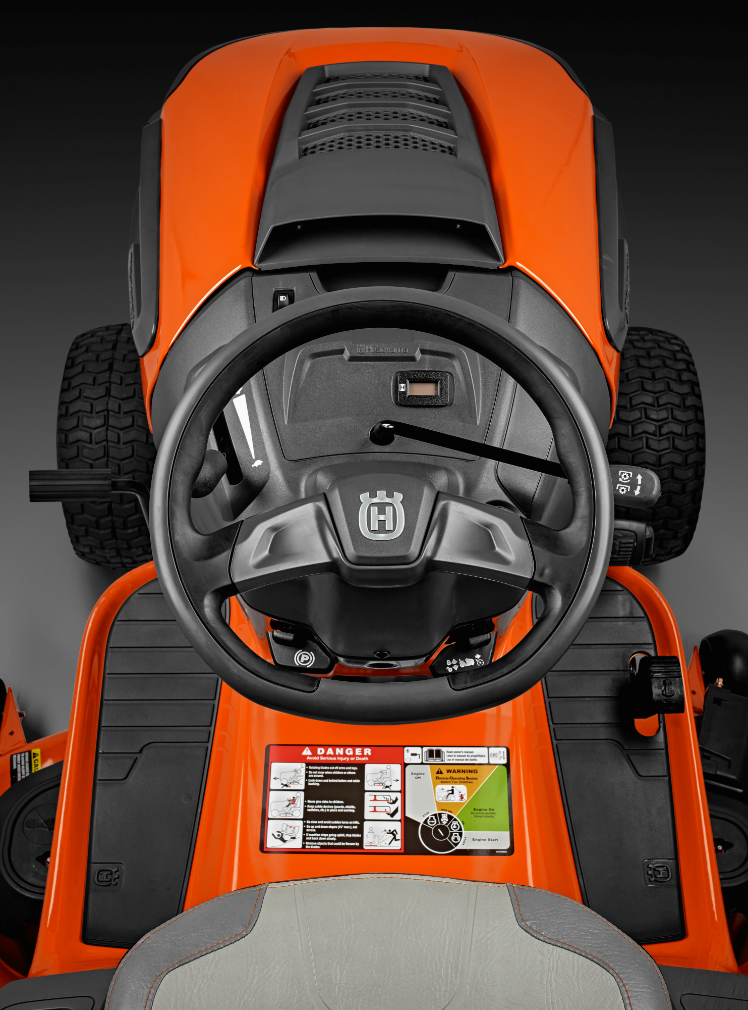 Oranžs Husqvarna zāles pļāvējs traktors, modelis ''TC 138'', skats no vadītāja viets uz vadības paneli