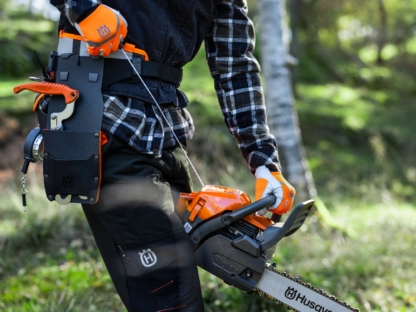 mežstrādnieks iedarbina Husqvarna motorzāģi